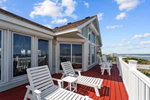 a porch with white chairs and a view of the ocean at 4099 - 3-2-1 Relax in Duck +100 photos