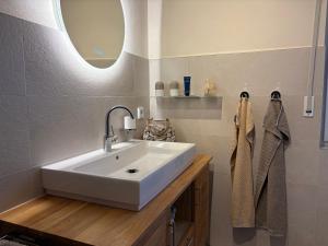 a bathroom with a white sink and a mirror at Ferienhaus EifelOne - Panorama in Heimbach +45 photos