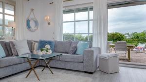 a living room with a couch and a table at Ferienhaus Weitblick in Morsum +6 photos