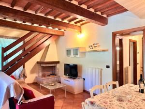 a living room with a dining table and a television at Ville Di Villa Biserno in San Vincenzo