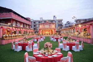 a banquet hall with tables and chairs in front of a building at Canalta Hotel Restaurant Bar in Jaipur +64 photos