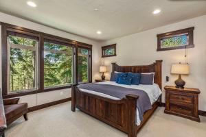 a bedroom with a bed with blue pillows and windows at 281 Big Rock in Cle Elum