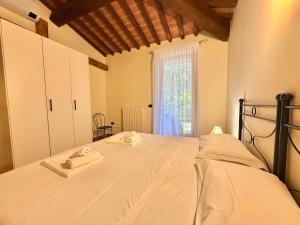 a bedroom with a bed with two towels on it at Ville Di Villa Biserno in San Vincenzo