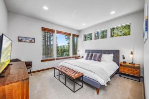 a bedroom with a bed and a desk and windows at Three Pines in Cle Elum