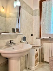 a bathroom with a white sink and a mirror at Ville Di Villa Biserno in San Vincenzo +25 photos