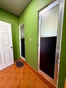 an empty room with green walls and a door at Casza Grande Alojamiento in La Libertad