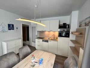 a kitchen with a table and chairs in a room at Appartementhaus Binzer Sterne 11 in Binz