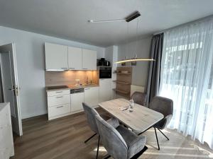 a kitchen and dining room with a table and chairs at Appartementhaus Binzer Sterne 11 in Binz