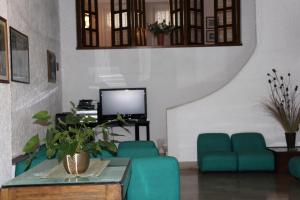 un soggiorno con sedie blu e TV di Hotel 2 Mari - Vieste a Vieste