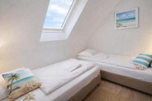 two beds in a room with a window at Fewo Lee in Kühlungsborn
