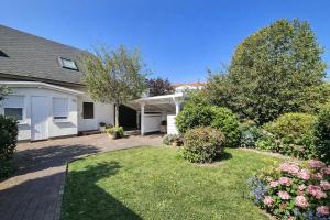 a house with a yard with flowers and plants at Fewo Lee in Kühlungsborn