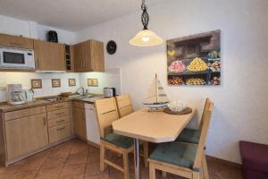 a kitchen with a wooden table and chairs and a sink at Fewo Lee in Kühlungsborn +2 photos