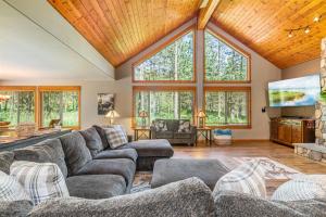a living room with a large couch and a tv at Playground in the Pines in Ronald