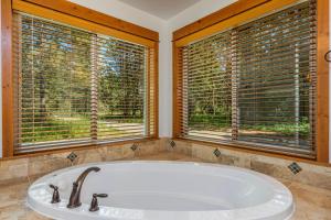 a bath tub in a bathroom with two windows at Playground in the Pines in Ronald +47 photos