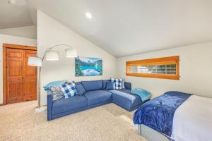 a living room with a blue couch and a bed at Playground in the Pines in Ronald
