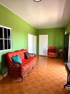 a living room with a red couch in a green wall at Casza Grande Alojamiento in La Libertad