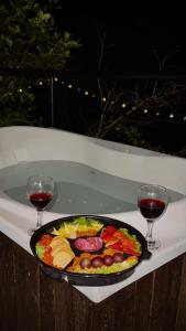 a plate of food on a table with two glasses of wine at GLAMPING EL PARAÍSO in Sasaima +42 photos