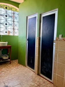 two doors in a bathroom with green walls and a sink at Casza Grande Alojamiento in La Libertad +29 photos