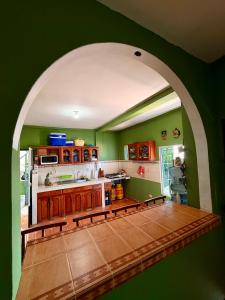 a kitchen with green walls and an archway in a room at Casza Grande Alojamiento in La Libertad