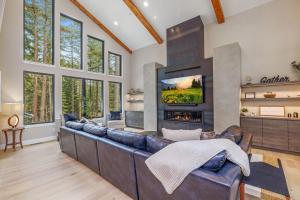 a living room with a leather couch and a fireplace at Mountain Modern Lodge in Cle Elum