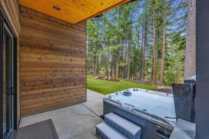 a hot tub on a patio next to a house at Mountain Modern Lodge in Cle Elum