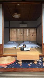 a room with a bed with a table in front of it at 海の風-春 in Wakayama