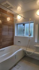 a bathroom with a bath tub and a window at 海の風-春 in Wakayama +57 photos