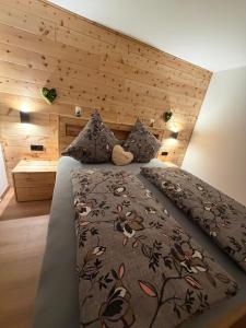 a bedroom with a large bed with a wooden headboard at Appartement Steinblick -Obinghof- in Maishofen
