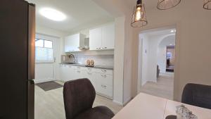 a kitchen with white cabinets and a table and chairs at Ferienwohnung "Ostseebrise" in Wendtorf in Wendtorf