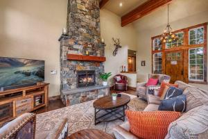 a living room with a stone fireplace and a tv at Tin Cup in Cle Elum