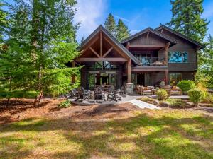 a large log house with a patio and trees at Gilden Glade Sanctuary in Cle Elum