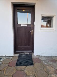 a brown door on a white building with a window at SelfossCenter flat in Selfoss