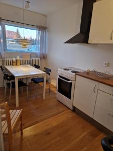 a kitchen and dining room with a table and a stove at SelfossCenter flat in Selfoss