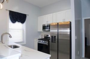 a kitchen with a stainless steel refrigerator and a stove at West New York room 20 in Guttenberg +12 photos