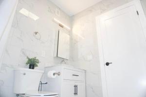 a white bathroom with a toilet and a sink at West New York room 20 in Guttenberg