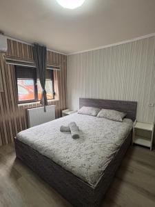 a bedroom with a large bed with two towels on it at My house in Constanţa