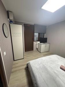 a bedroom with a bed and a desk and a television at My house in Constanţa