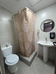 a bathroom with a toilet and a sink and a mirror at My house in Constanţa
