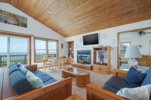 a living room with blue couches and a television at 2931 - Lighthouse in Duck