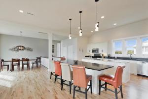 a kitchen and dining room with a large island with orange chairs at 4108 - New Beginnings in Duck +47 photos