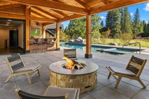 a patio with a fire pit and chairs and a pool at Grand Retreat in Cle Elum