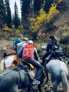 a group of people riding horses on a trail at East guest house in Tegermenti