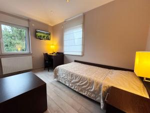 a bedroom with a bed and a desk in it at Hotel Casa Borghese in Senningerberg