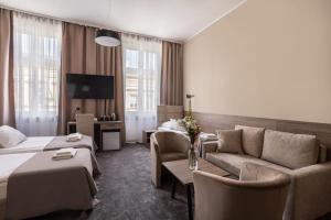 a hotel room with a bed and a couch at Hotel Maksymilian in Krakow