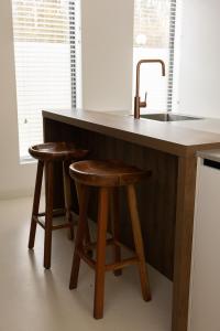 a kitchen counter with two stools and a sink at Vakantiepark De Kremmer in Gasselte +33 photos