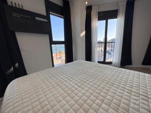 a bedroom with a bed with a large window at MINA MAR 1ª línea playa ADULTS ONLY in Vinarós