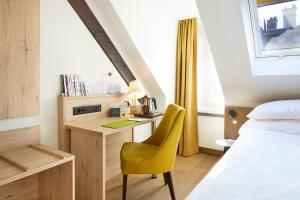 a bedroom with a desk and a yellow chair at PLATZHIRSCH ZÜRICH - Downtown Boutique Hotel & Sushi Lounge in Zurich