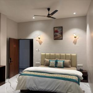 a bedroom with a large bed with a ceiling fan at Hotel Blue Ocean in Bharweli