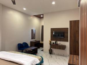 a bedroom with a bed and a desk and a chair at Hotel Blue Ocean in Bharweli