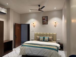 a bedroom with a bed and a ceiling fan at Hotel Blue Ocean in Bharweli